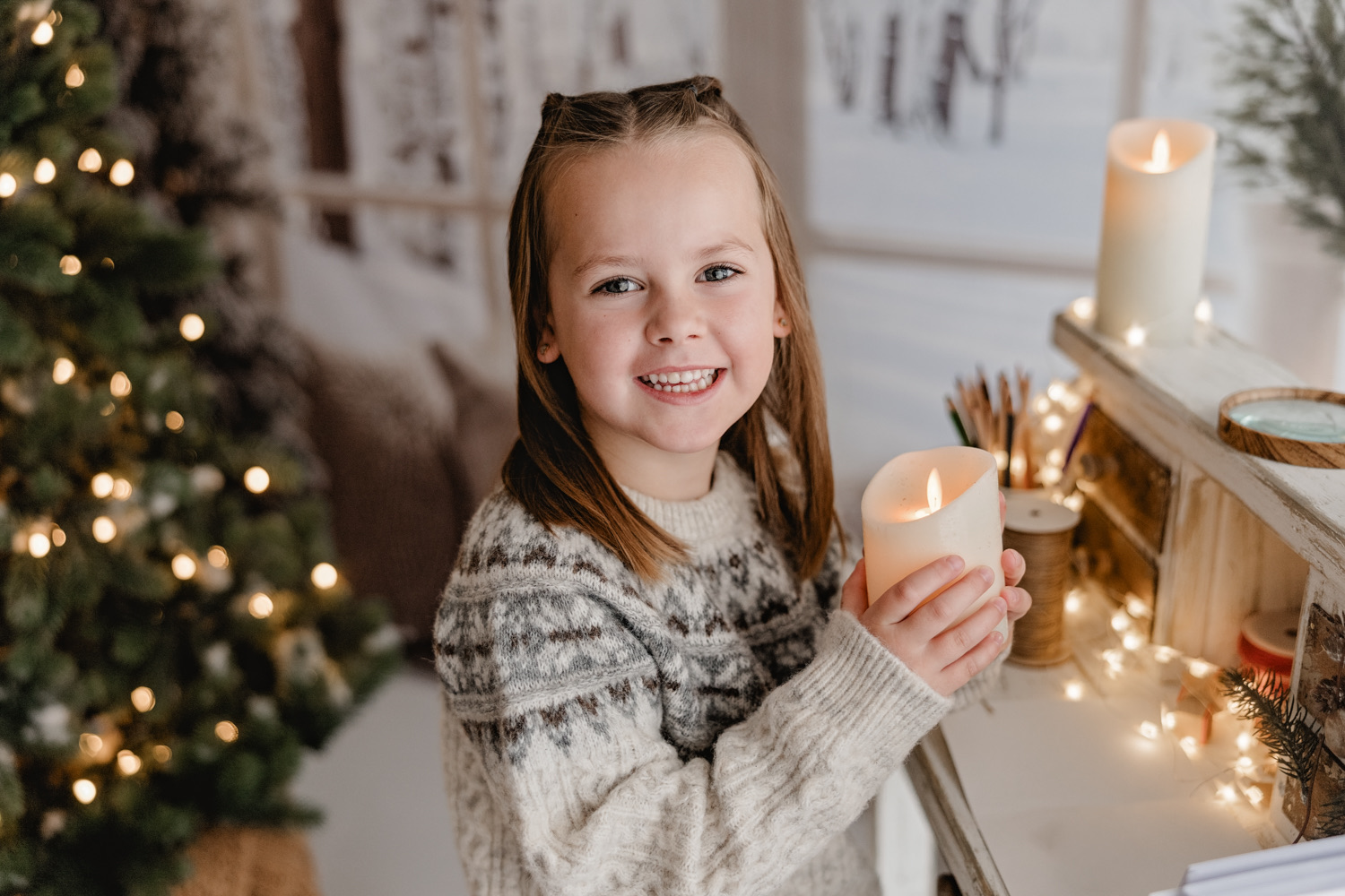 Kind im hellen Weihnachtsset mit Kerzen
