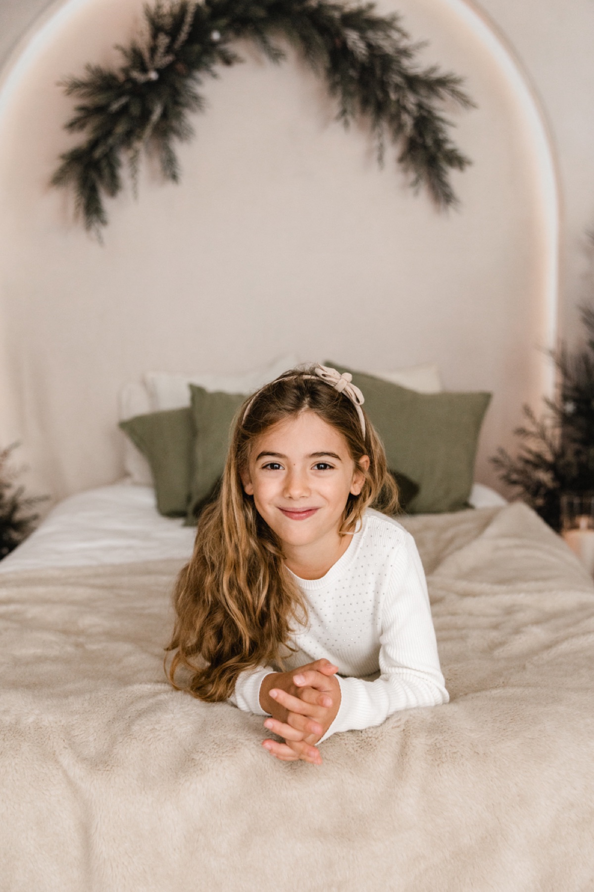 Kinderportrait im hellen weihnachtlichen Bett-Set